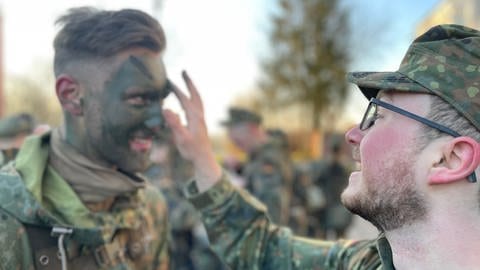 Ein Rekrut im Freiwilligen Wehrdienst im Heimatschutz in Bruchsal wird zur Tarnung im Gesicht geschminkt, bevor es in den Wald ins Biwak geht. (Foto: SWR)