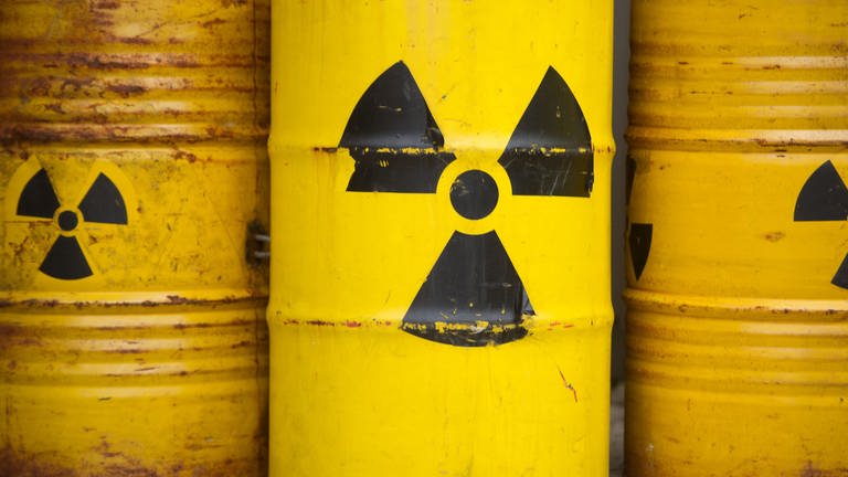 Gelbe Fässer mit Atommüll und dem Zeichen für Radioaktivität