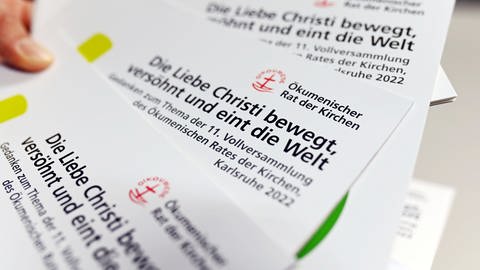 Flyer zur Vollversammlung des ökumenischen Rat der Kirchen, die 2022 in Karlsruhe stattfindet. (Foto: picture-alliance / Reportdienste, dpa Bildfunk, Uli Deck)