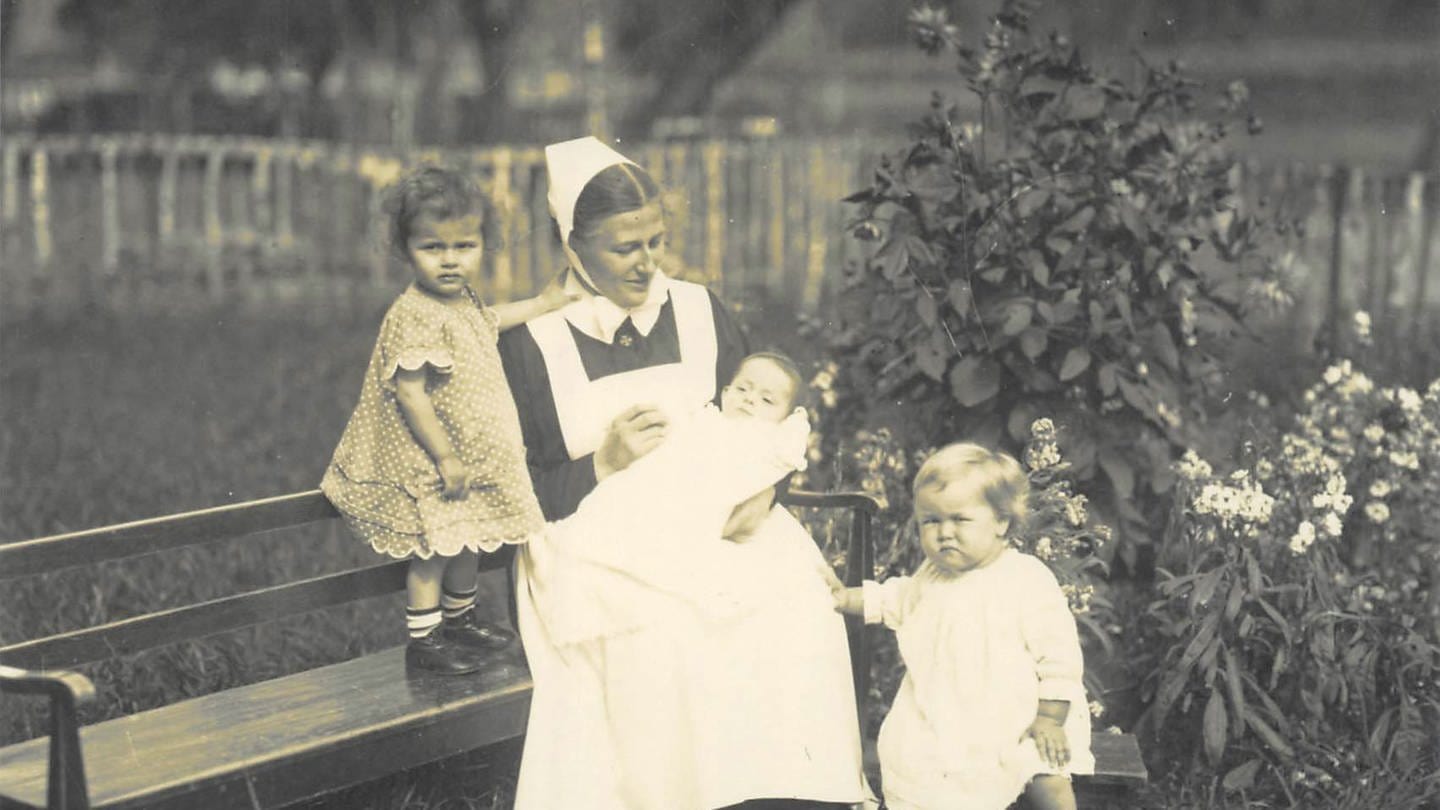 1923 Diakonisse mit Säugling auf Sitzbank