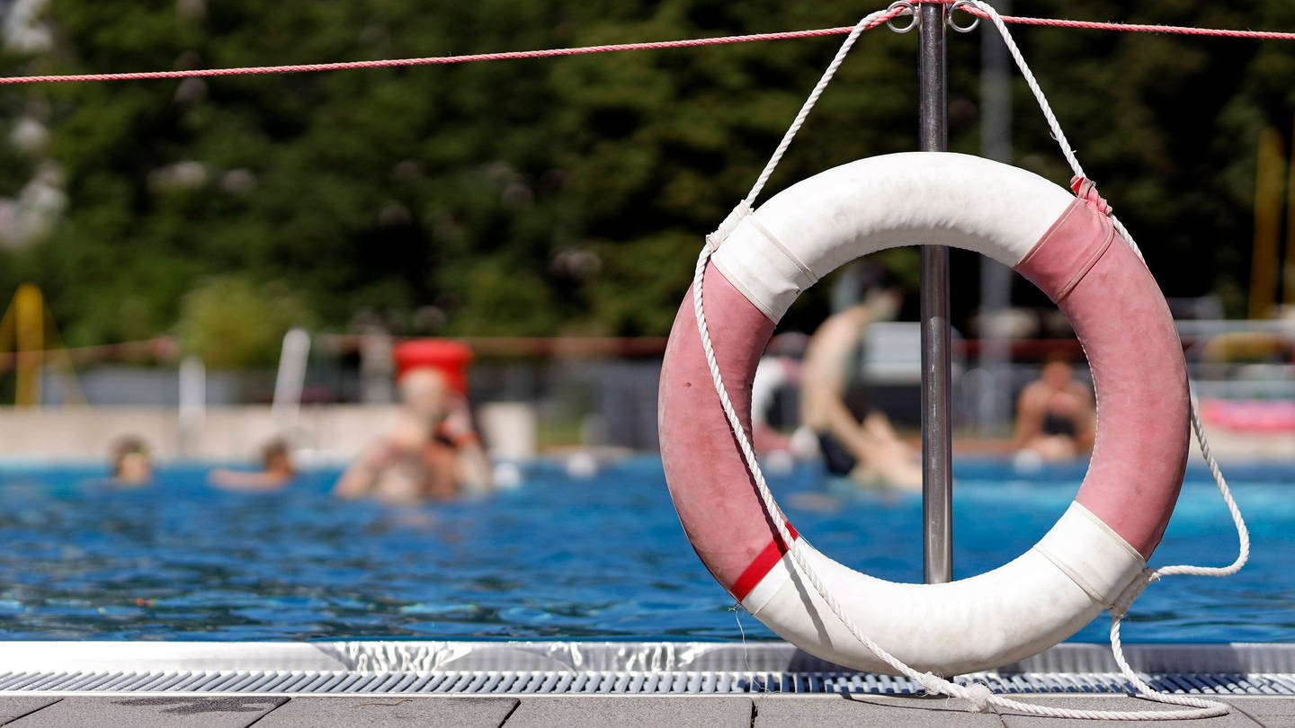 Ein Rettungsring hängt am Geländer eines Schwimmbeckens im Freibad