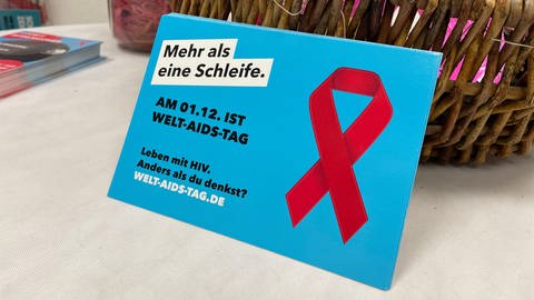 Plakat mit roter AIDS-Solidaritäts-Schleife und der Aufschrift: "Am 01.12. ist Welt-AIDS-Tag" (Foto: SWR, Susann Bühler)
