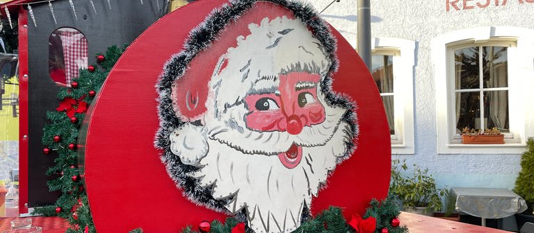 Ein großes Weihnachtsmanngesicht auf einer Bude auf dem Bruchsaler Wintermarkt (Foto: SWR)