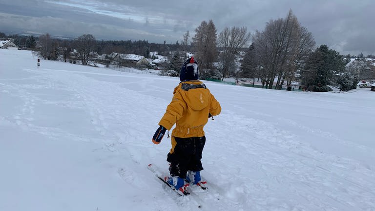 Ein kleiner Junge steht am Dobel (Landkreis Calw) auf Skiern im frisch geschneiten Schnee (Foto: SWR, Heiner Kunold)