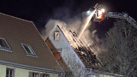 Feuerwehrleute auf Drehleiter löschen Wohnhausbrand (Foto: Einsatz-Report24)
