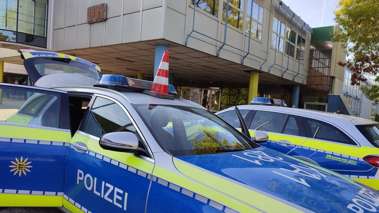 Polizeifahrzeuge stehen vor dem Thomas-Mann-Gymnasium in Stutensee-Blankenloch (Foto: Pressestelle, Thomas Riedel)