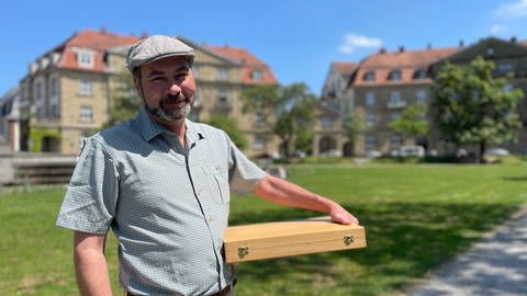 Der Hobby-Historiker Marc Scheffler hat eine Holzkiste mit den Dokumenten unter dem Arm. (Foto: SWR)
