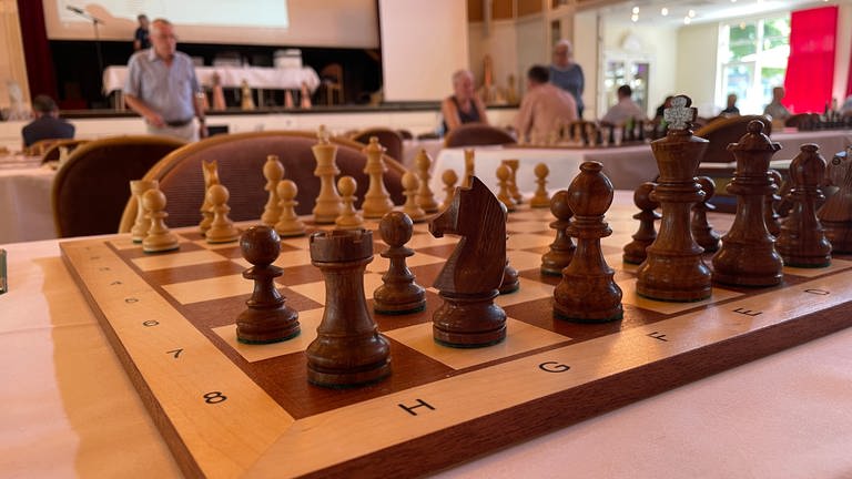 Ein aufgebautes Schachbrett vor dem Hintergrund eines Schachturniers (Foto: SWR, Markus Volk)