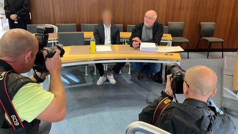Dem Angeklagten (li.) wird versuchte räuberische Erpressung gegen den Sohn von Winfried Schäfer vorgeworfen. Er erschien mit seinem Anwalt vor dem Amtsgericht Karlsruhe. (Foto: SWR)