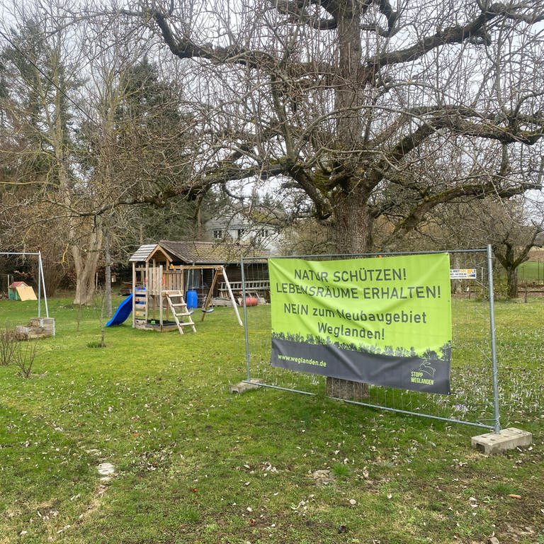 Ein Demoplakat der Bürgerinitiative Weglanden an einem Zaun in einem Garten in Ispringen im Enzkreis. Eigentlich braucht die Gemeinde mehr Wohnraum, aber es gibt Bedenken um den Naturschutz eines Neubaugebiets.  (Foto: SWR)