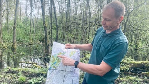 Revierförster Markus Rudolph im Gemeindewald in Sinzheim mit einer detailierten Karte des Waldes (Foto: SWR, Foto: Johannes Stier )