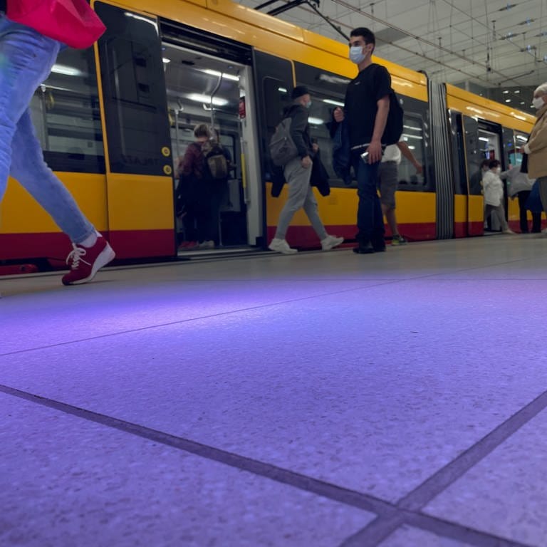 Im Vordergrund ein Lichtkegel auf dem Bahnsteig in einer Karlsruher U-Bahn-Haltestelle, im Hintergrund eine Stadtbahn und Fahrgäste. (Foto: SWR)