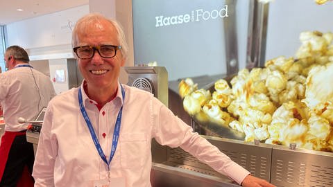 Unternehmer Helmut Haase zeigt seine neuesten Popcorn-Maschinen (Foto: SWR, Patrick Neumann, SWR)