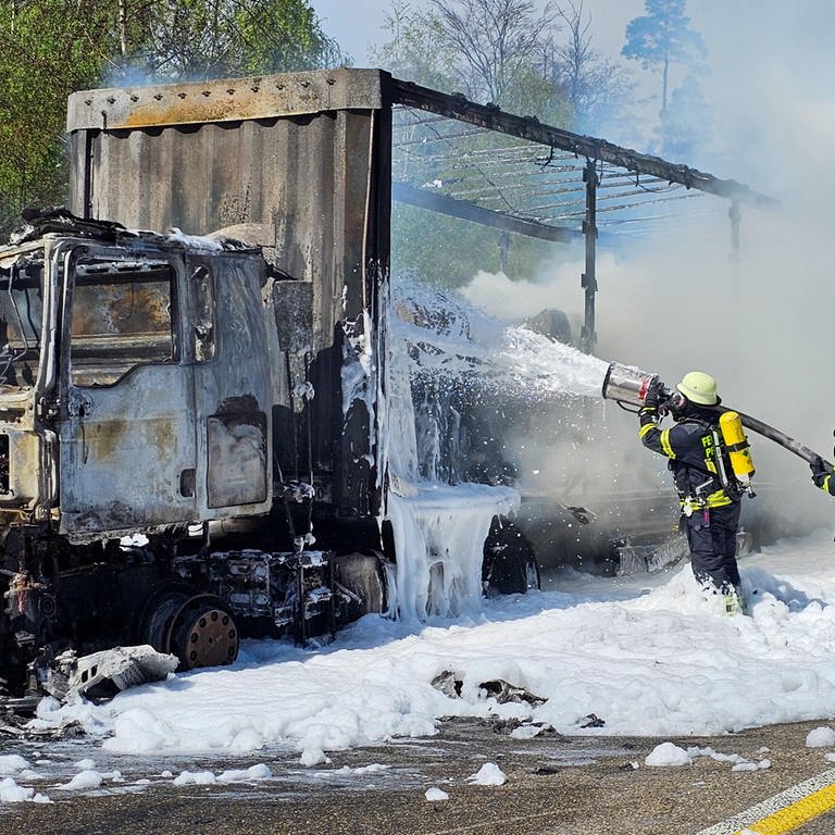 Die Feuerwehr löscht einen ausgebrannten Lkw auf der A8