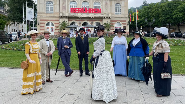 Mehrere Menschen in historischen Kostümen stehen vor dem Theater in Baden-Baden (Foto: SWR, SWR, Teo Jägersberg)