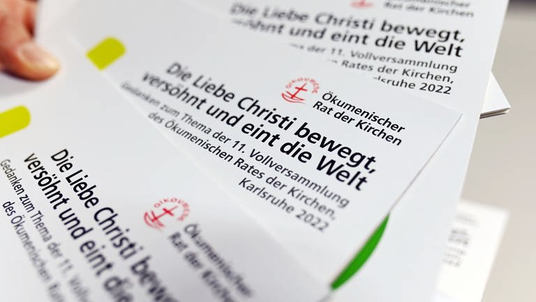Flyer zur Vollversammlung des ökumenischen Rat der Kirchen, die 2022 in Karlsruhe stattfindet. (Foto: picture-alliance / Reportdienste, dpa Bildfunk, Uli Deck)
