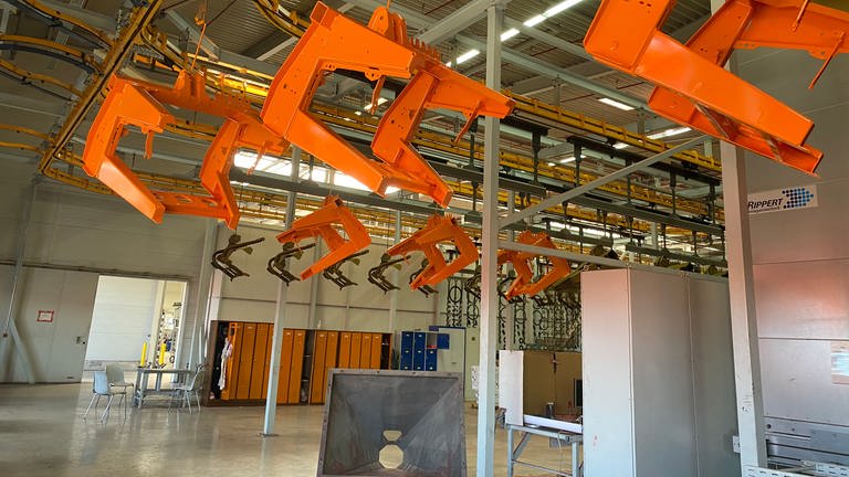 Frisch lackierte Landmaschinenteile hängen in der Halle von RAUCH am Standort auf dem Baden Airpark. (Foto: SWR, SWR/LauraBisch)