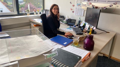 Alina Hauser, Mitarbeiterin im Rathaus Neulingen im Enzkreis, sitzt an ihrem Schreibtisch und telefoniert (Foto: SWR)