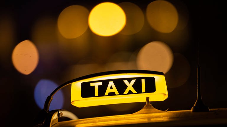 Ein leuchtendes Taxischild in der Nacht (Foto: IMAGO, IMAGO / MiS)