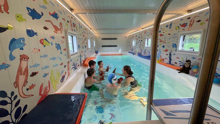 Blick in das Becken des mobilen Schwimmbads. Mehrere Kinder und eine Betreuerin sind im Wasser. (Foto: SWR, Felix Wnuck)