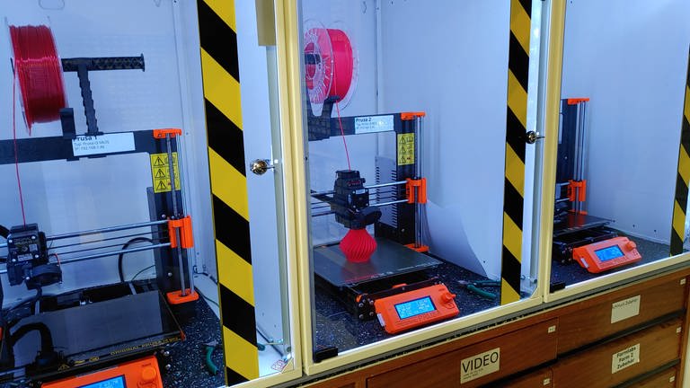 Drei 3D-Drucker sind zu sehen, auf einem wird eine Vase gedruckt
