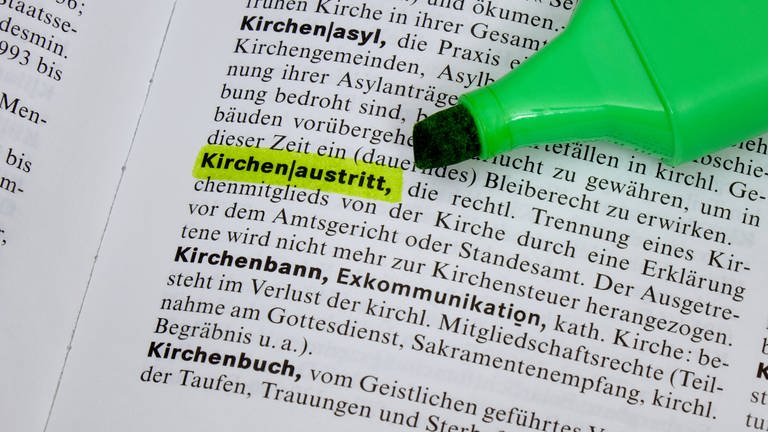 Das markierte Wort "Kirchenaustritt" in einem Lexikon (Foto: IMAGO, IMAGO / Steinach)