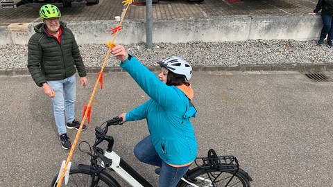 E-Bike-Fahrer bekommen Fahrsicherheitstraining: Während des Fahrens über Kopf an eine Leine mit Wäscheklammern gehört dazu (Foto: SWR, Heiner Kunold)