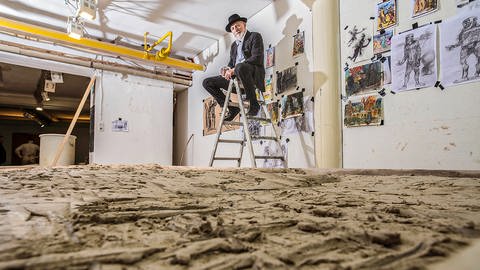 Künstler Markus Lüpertz "thront" auf einer Leiter über einer seiner Keramiktafeln, die er für die Karlsruher Kombilösung produziert. (Foto: Karlsruhe Kunst Erfahren)