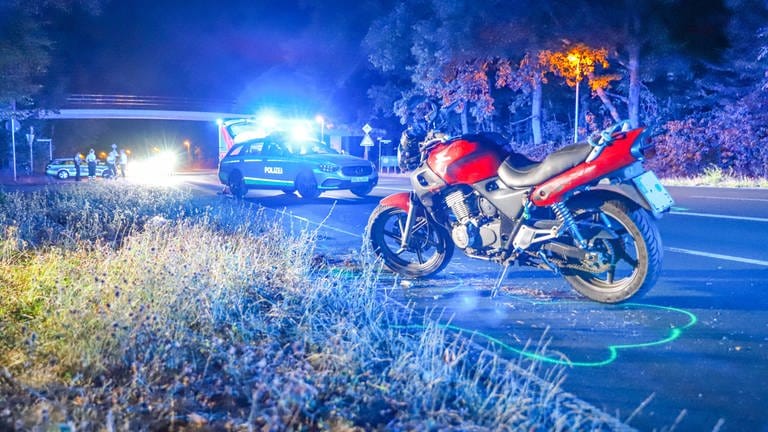 Ein Motorrad steht nach einem Unfall mit einem Radfahrer auf der Straße. 