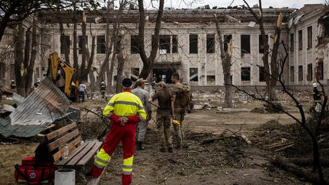 Soldaten und Feuerwehrleute stehen am Ort der Raketeneinschläge, die am Vortag das Zentrum von Winnyzja, einer Stadt im Osten der Ukraine, getroffen haben.  (Foto: picture-alliance / Reportdienste, Picture Alliance)
