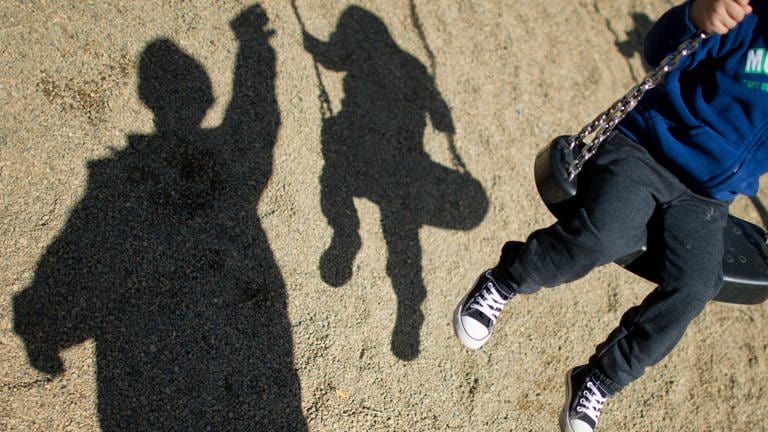 Schatten eines Kindes auf der Schaukel (Foto: picture-alliance / Reportdienste, picture alliance / dpa | Julian Stratenschulte (Symbolbild))