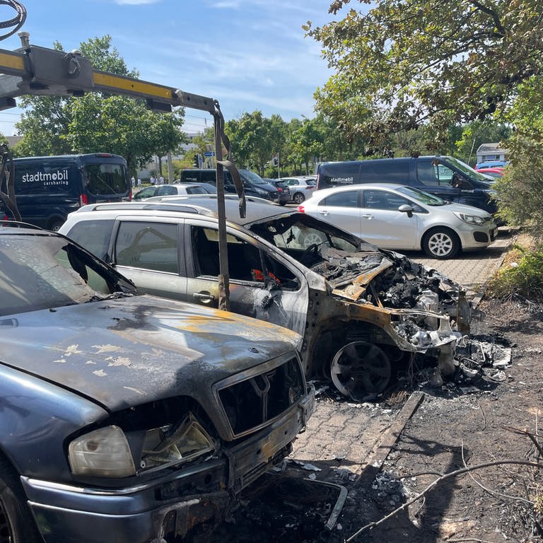 Abgebrannte Autos in der Waldstadt in Karlsruhe stehen am Straßenrand