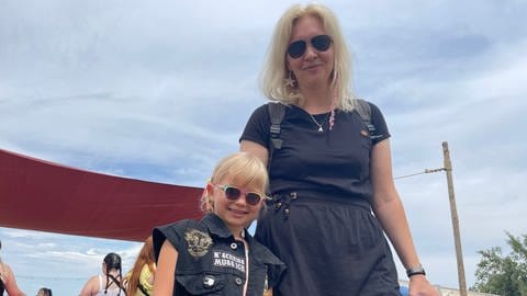 Mutter mit Kind besuchen in coolen, schwarzen Outfits das Happiness Festival in Straubenhardt (Foto: SWR, Mirka Tiede)
