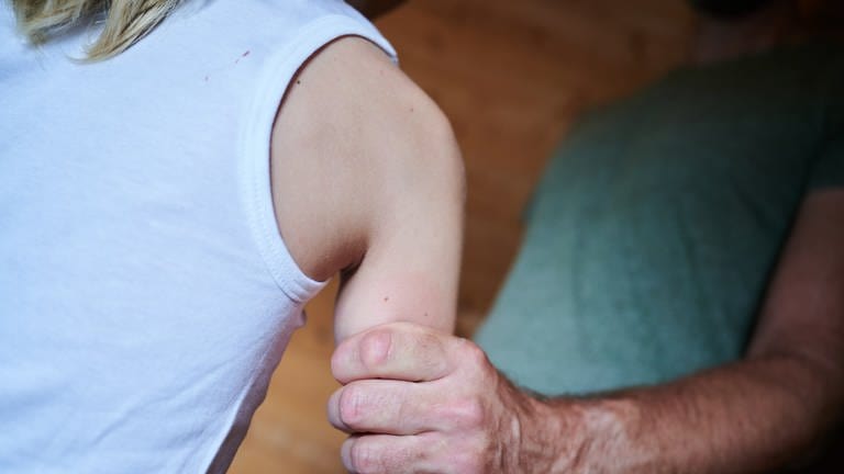 Symbolbild Missbrauch: Mann hält ein Kind fest am Arm (Foto: dpa Bildfunk, picture alliance/dpa | Annette Riedl)