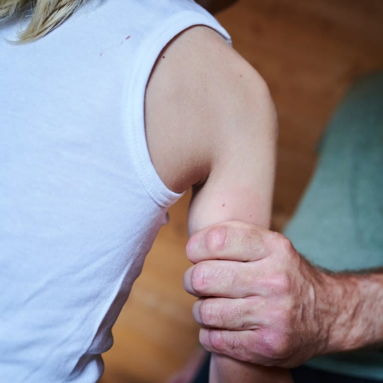 Symbolbild Missbrauch: Mann hält ein Kind fest am Arm