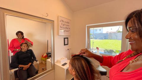 Bei jedem Wettkampf eine neue Frisur: Mikaelle Assanis Mutter kümmert sich immer um die Haare der Sportlerin. Die Weitspringerin aus Karlsruhe tritt bei der Leichtathletik WM in Budapest an. (Foto: SWR, Mirka Tiede)