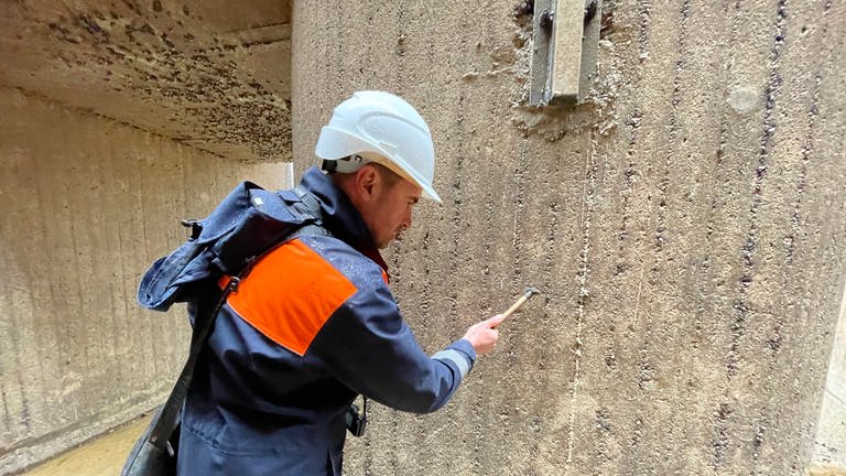 Reparaturarbeiten an der Schleuse Iffezheim: Betonwände der Schleusenkammer werden mit einem Hammer auf Schäden abgeklopft. (Foto: SWR, Cornelia Stenull)