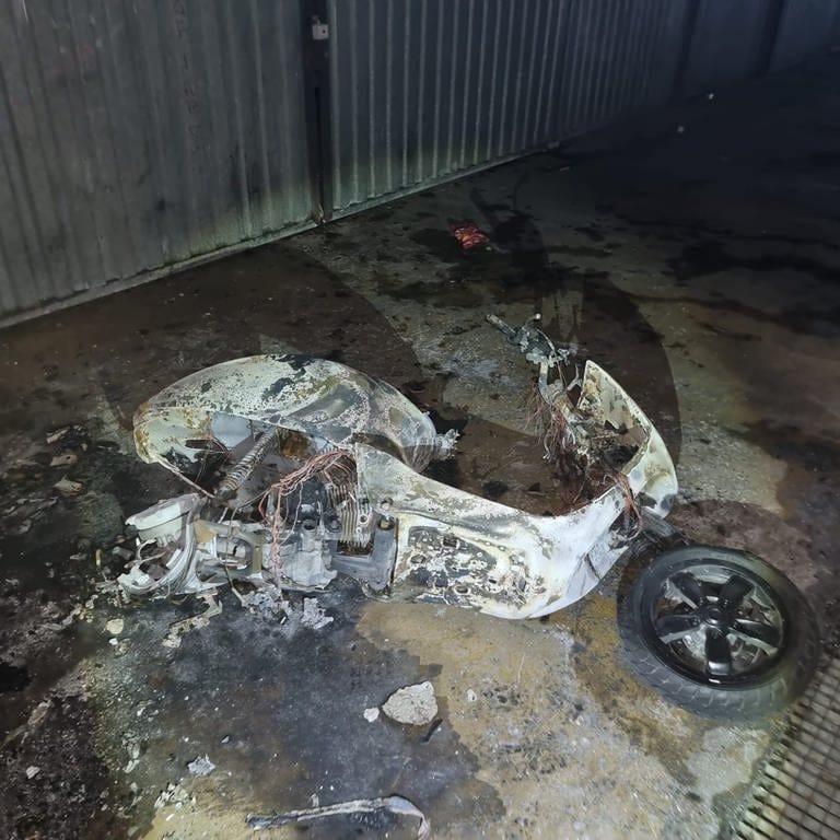 Ein Roller liegt nach einem Brand in einer Tiefgarage in Karlsruhe auf dem Boden.