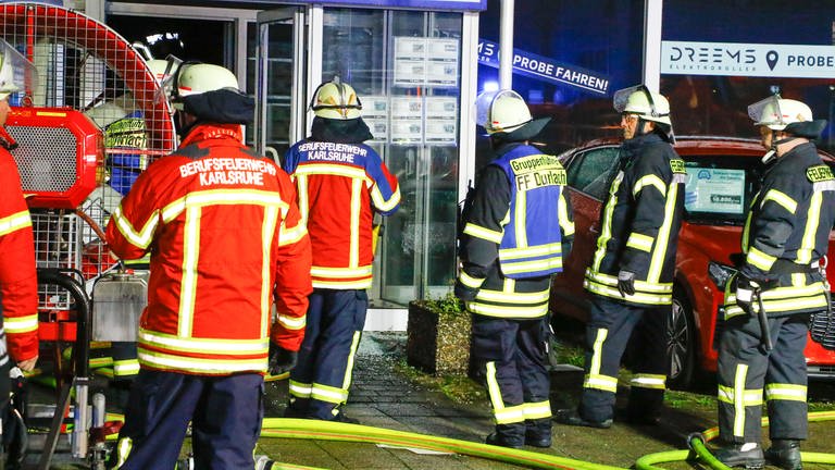 Feuerwehrmänner vor dem Eingang eines Autohauses (Foto: Pressestelle, Tim Müller / EinsatzReport24)