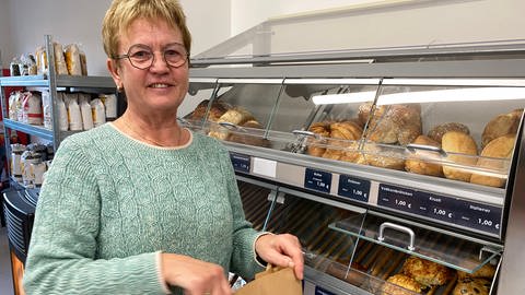 Dorothea Müller-Laube arbeitet als Helferin im Dorfladen von Mühlhausen. Sie befüllt die Auslage mit Backwaren, die täglich von einer Bäckerei geliefert werden. (Foto: SWR, Peter Lauber)