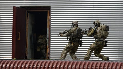 Soldaten des Kommandos Spezialkräfte (KSK) aus Calw stürmen auf dem Kasernengelände während einer Übung in eine Tür. 