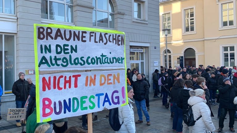 Bei einer Demonstration gegen Rechtsextremismus in Karlsruhe steht "Braune Flaschen in den Altglascontainer, nicht in den Bundestag!" auf einem Plakat.