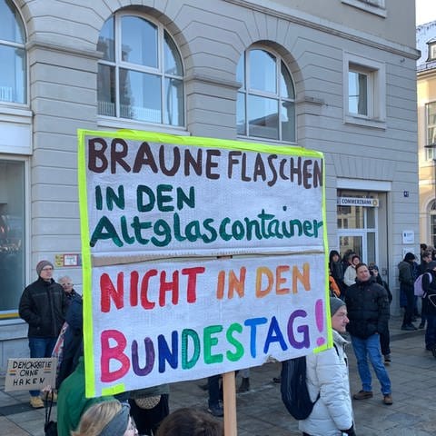 Bei einer Demonstration gegen Rechtsextremismus in Karlsruhe steht "Braune Flaschen in den Altglascontainer, nicht in den Bundestag!" auf einem Plakat.