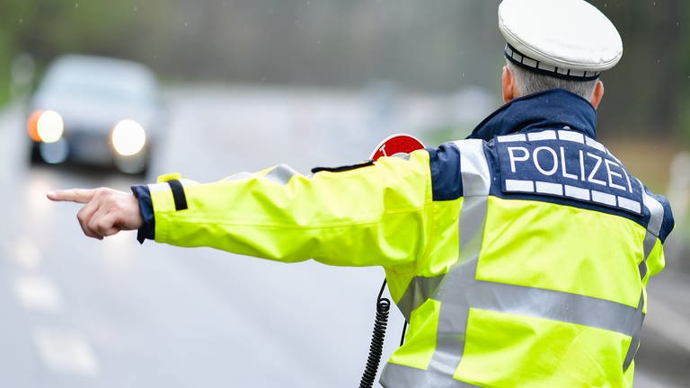 Ein Autofahrer fuhr auf seiner Flucht vor einer Polizeikontrolle eine Frau in Gaggenau an. Polizei macht Haltesignal für einen Autofahrer.