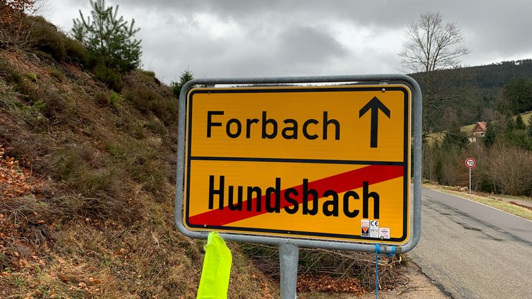Das Ortsschild im Schwarzwald zeigt den Weg Richtung Forbach, der Ortsname Hundsbach ist durchgestrichen.