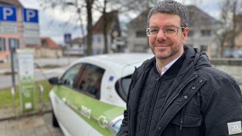 Der Bürgermeister von Forst im Kreis Karlsruhe, Bernd Killinger, vor einem Elektroauto des "ZEO Carsharing" Projekts. (Foto: SWR)