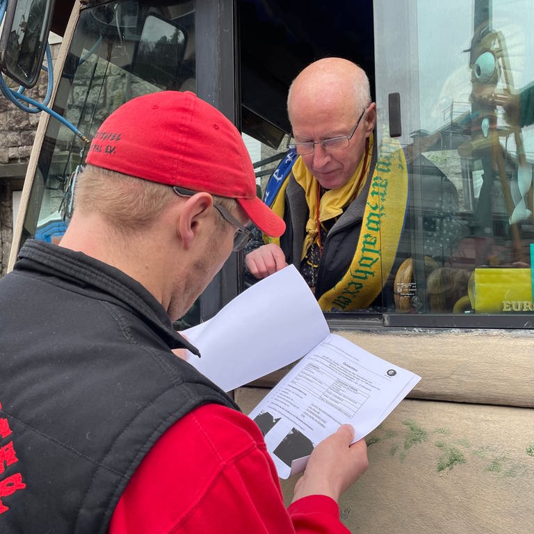 Vor dem Start des Rosenmontagszugs in Bühlertal prüft Umzugsleiter Michael Beyrle die TÜV-Papiere bei den Fastnachtswagen.