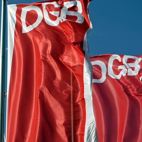 Fahnen des Deutschen Gewerkschaftsbunds (DGB) wehen vor dem blauen Himmel. Der DGB hat am 1. Mai wieder zu Kundgebungen aufgerufen. (Foto: dpa Bildfunk, picture alliance/dpa/dpa-Zentralbild | Jan Woitas)