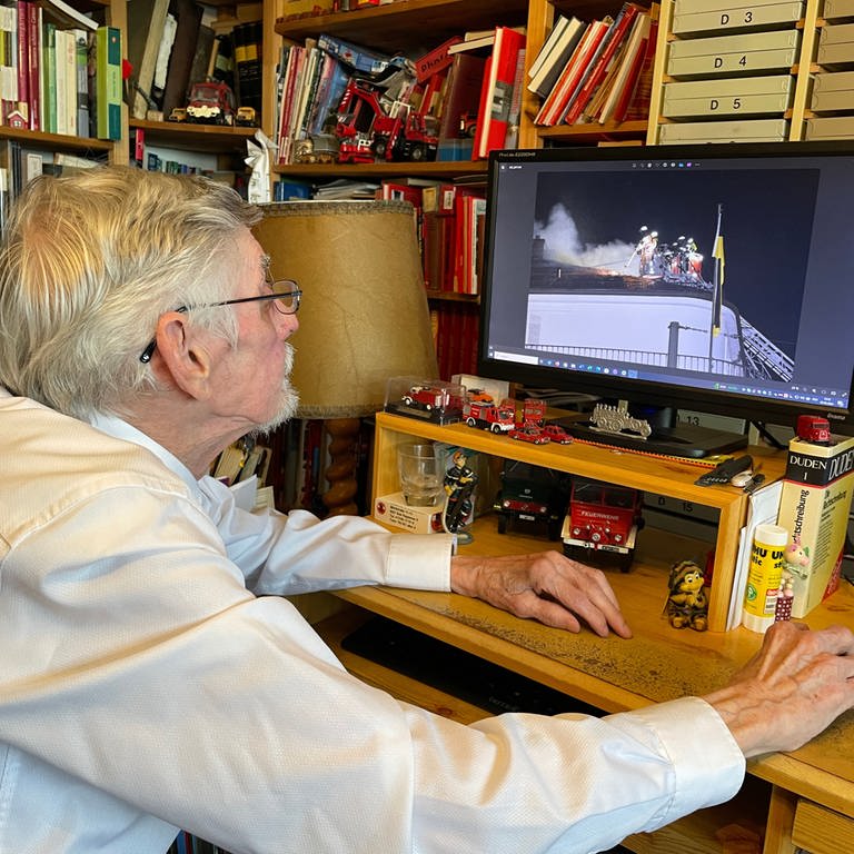 Bertold Wagner sichtet am Computer Fotos von den Brandeinsätzen