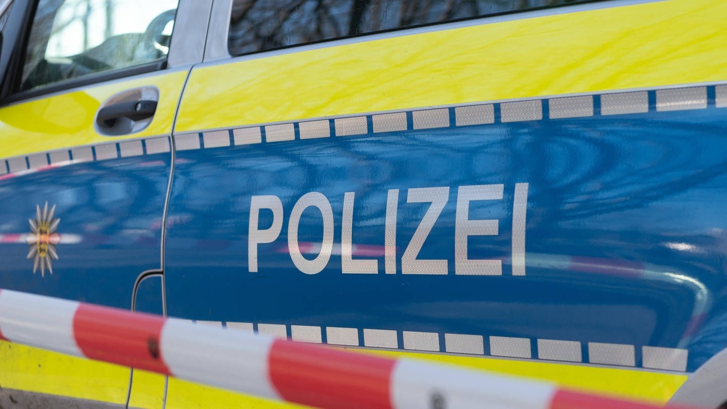 Symbolbild: Ein Polizeiauto mit einem Absperrband. In Straubenhardt im Enzkreis hat ein Brand ein Einfamilienhaus unbewohnbar gemacht. (Foto: IMAGO, Eibner (Symbolbild))
